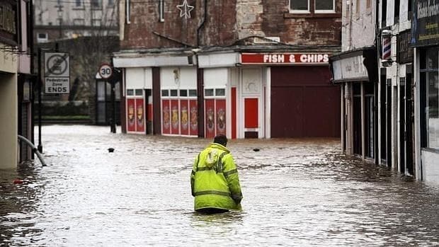 Una persona camina por una calle en Inglaterra, durante las inundaciones de diciembre