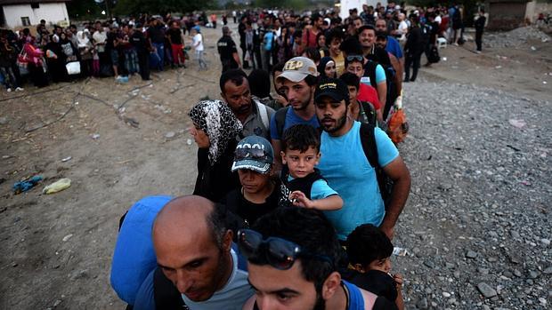 Inmigrantes esperan la autorización para abordar un tren y cruzar la frontera entre Macedonia y Grecia