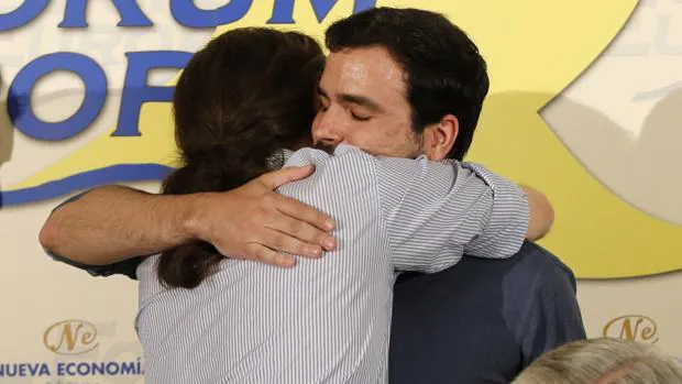 Pablo Iglesias y Alberto Garzón se abrazan durante el foro Nueva Economía