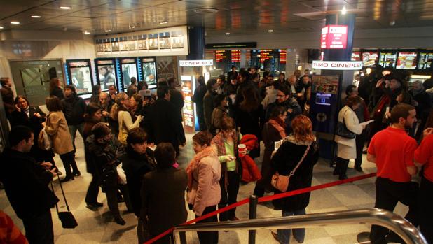 Varios espectadores a la entrada de un cine en Madrid