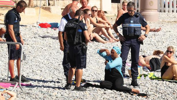 Los policías se acercan a la mujer con «hijab»