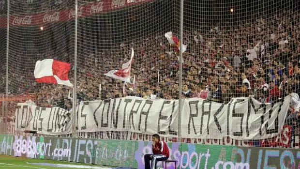 La aficción del Sevilla Futbol Club porta una gran pancarta en contra del racismo