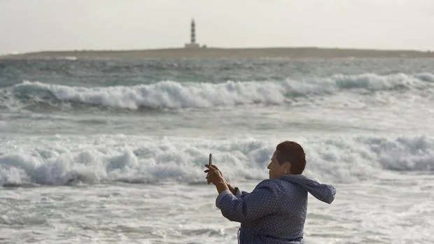 Una mujer toma una fotografía del temporal en Menorca