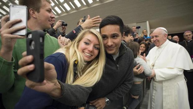 Unos jóvenes se hacen un selfie con el Papa en la audiencia del miércoles