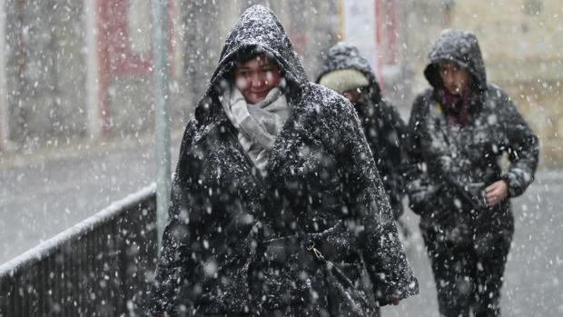 Varias personas en el pueblo de Bunyola, a los pies de la Serra de Tramuntana (Mallorca), donde la acumulación de nieve en la calzada obligó a cortar el tráfico