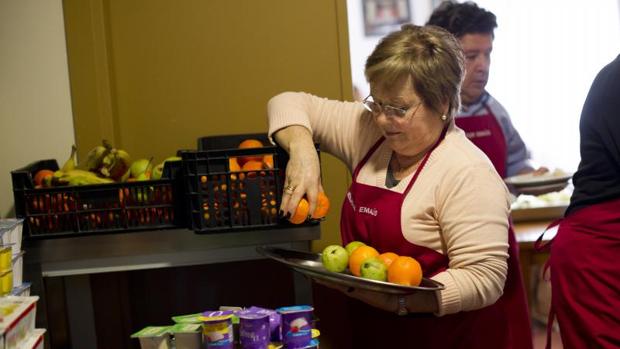 Un grupo de voluntarios preparan los platos para los usuarios de un comedor social en Barcelona