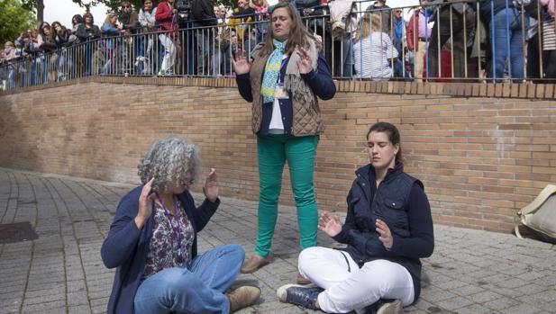 Tres asistentes a «Being one» meditan en los aledaños de la plaza de toros de Leganés