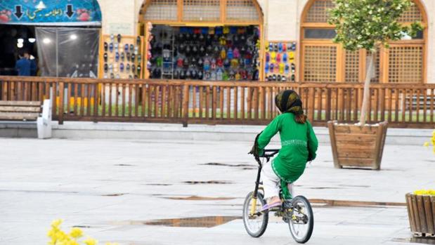 Una joven iraní pasea en su bicicleta