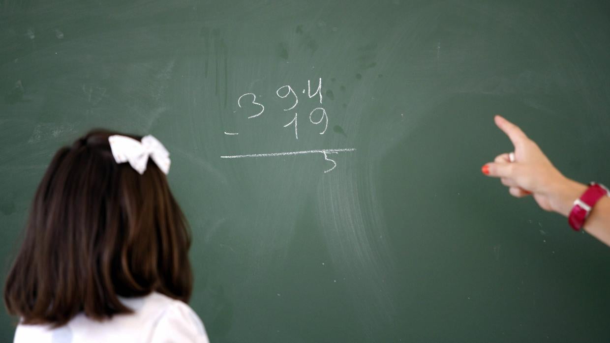 Niña frente a una pizarra en un colegio