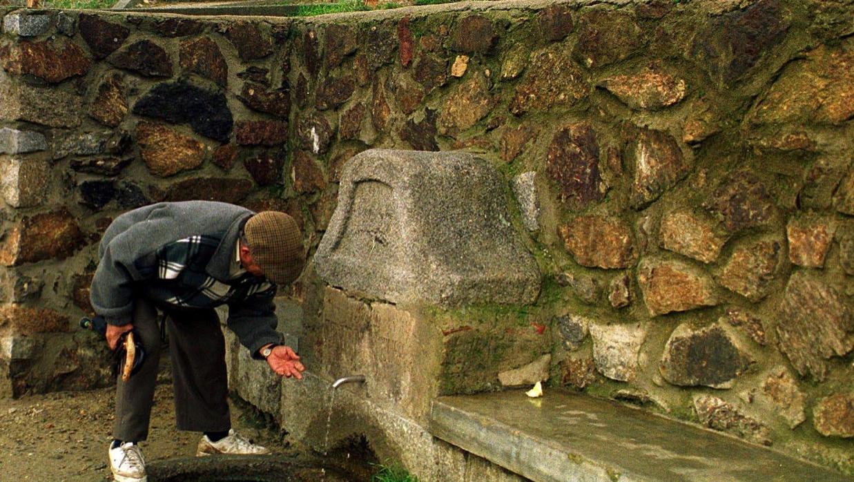 Un hombre bebe agua de una fuente no potable