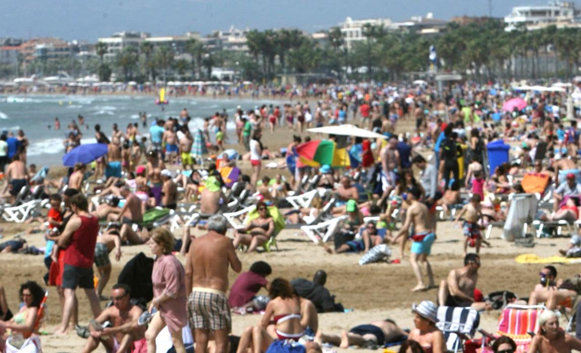 Varias personas pasan sus vacaciones en la playa del levante