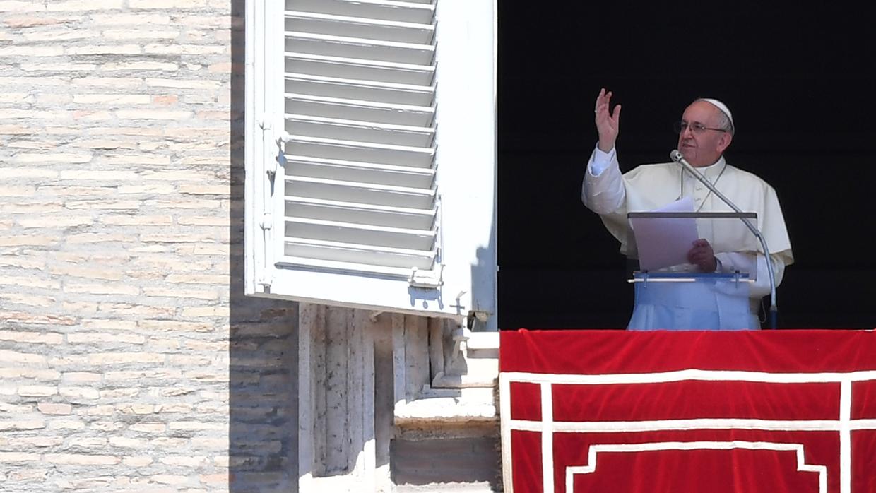 El Papa Francisco saluda a la multitud desde la ventana del palacio apostólico que domina la plaza de San Pedro durante la oración del Angelus dominical