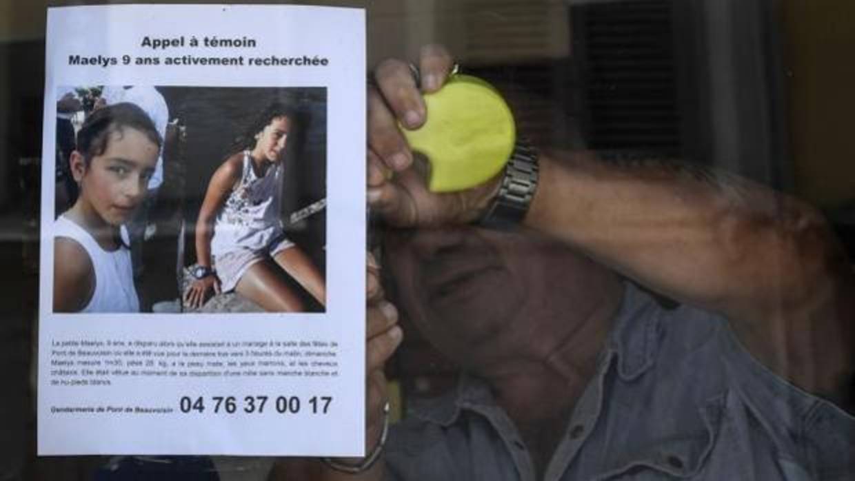 Un hombre coloca un cartel con la alerta por la desaparición de Maëlys