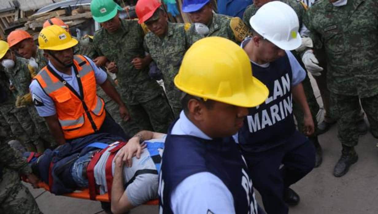 Miembros del Ejército mexicano y voluntarios trasladan a un voluntario lesionado, en el colegio Enrique Rébsamen