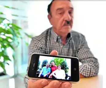 Cayetano Ros, padre de la víctima, muestra una foto de la joven junto a sus padres.
