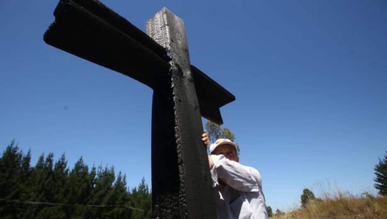 Un hombre se apoya en una cruz en Cunco, en la región chilena de Araucania