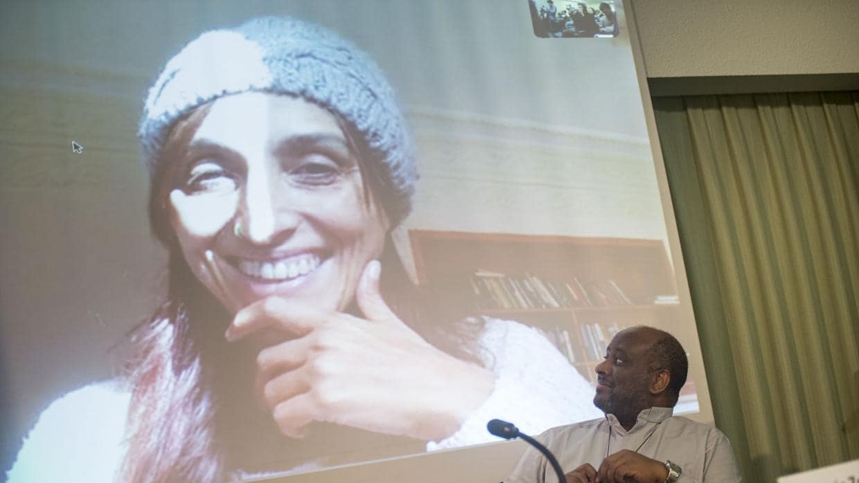 La activista española Helena Maleno en la pantalla junto al sacerdote eritreo Mussie Zerai
