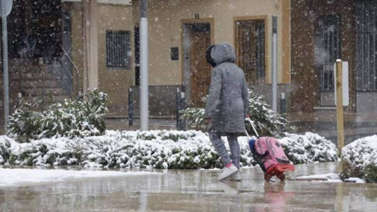 Una mujer camina bajo la nieve que cayó este martes sobre Utiel y que ha obligado a suspender las clases en varios municipios