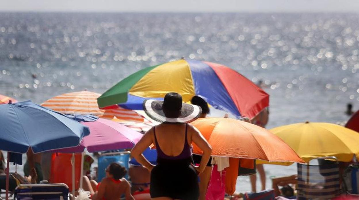 Turistas disfrutan del sol y el agua en la playa de Levante de Benidorm