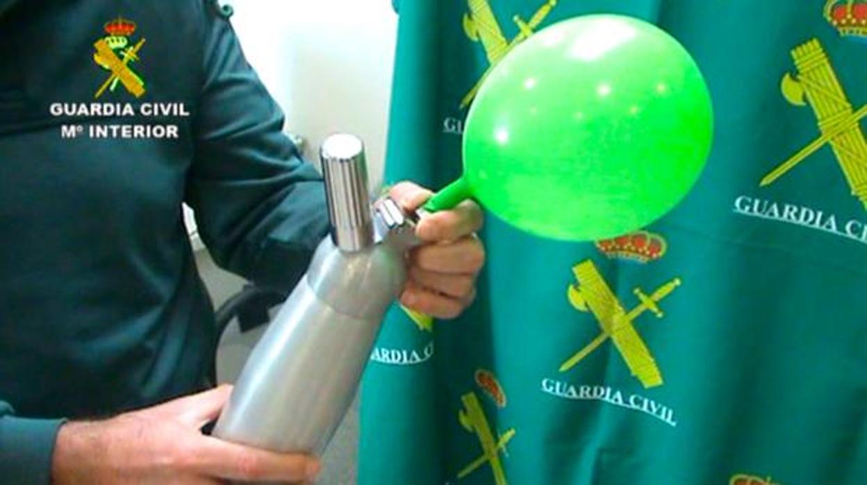 Agente de la Guardia Civil hinchando un globo con Óxido nitroso