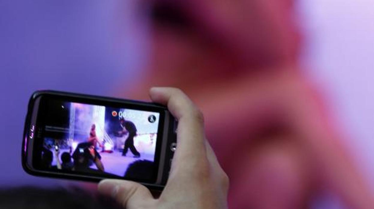 Un hombre tomando una foto de una exhibición porno en Niza