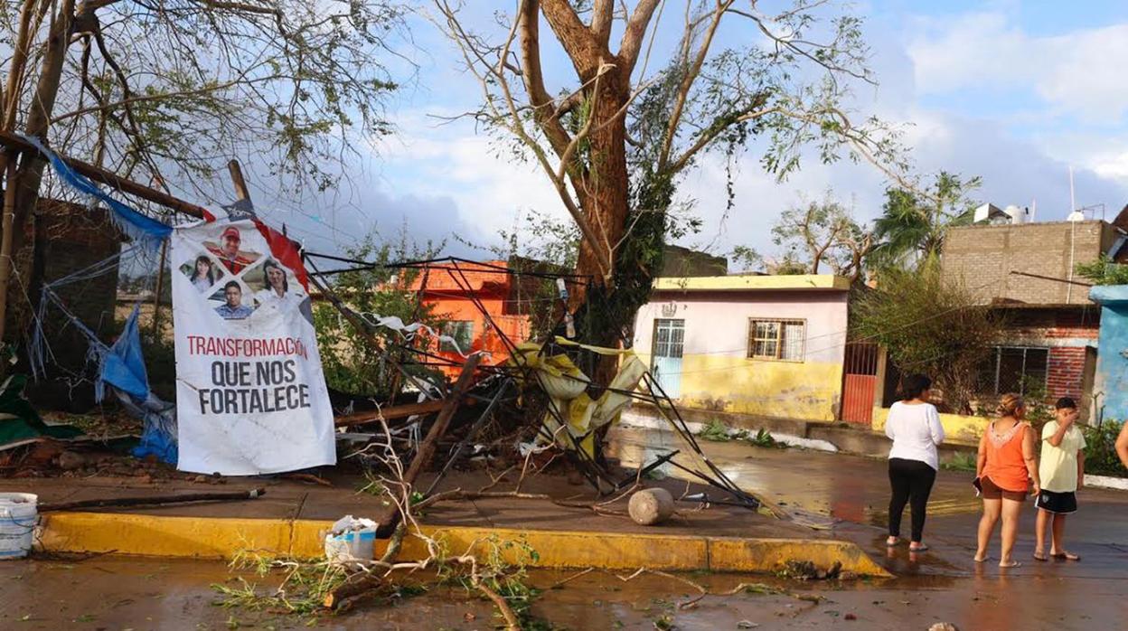 Varias personas permanecen junto a unos árboles caídos en la población de Escuinapa, en el estado de Sinaloa (México), tras el paso del huracán Willa