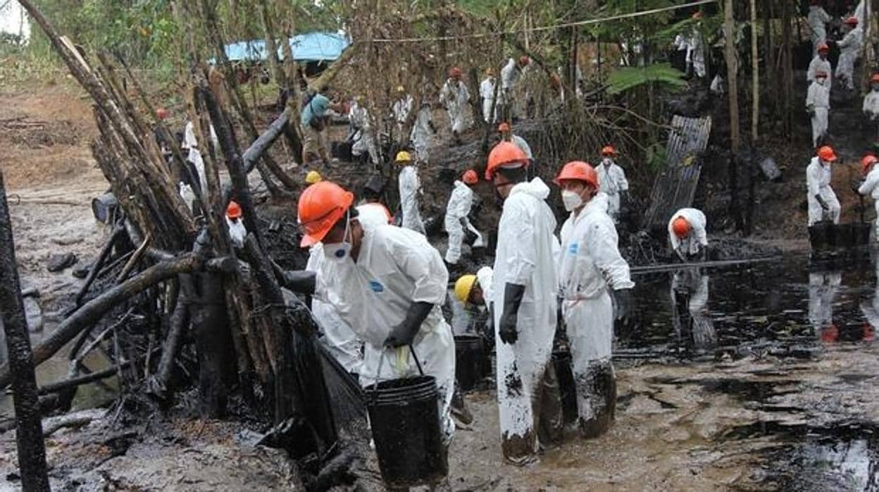 Un grupo de trabajadores recogen crudo en la quebrada Inayo (región Amazonas) tras la fuga del 25 de enero