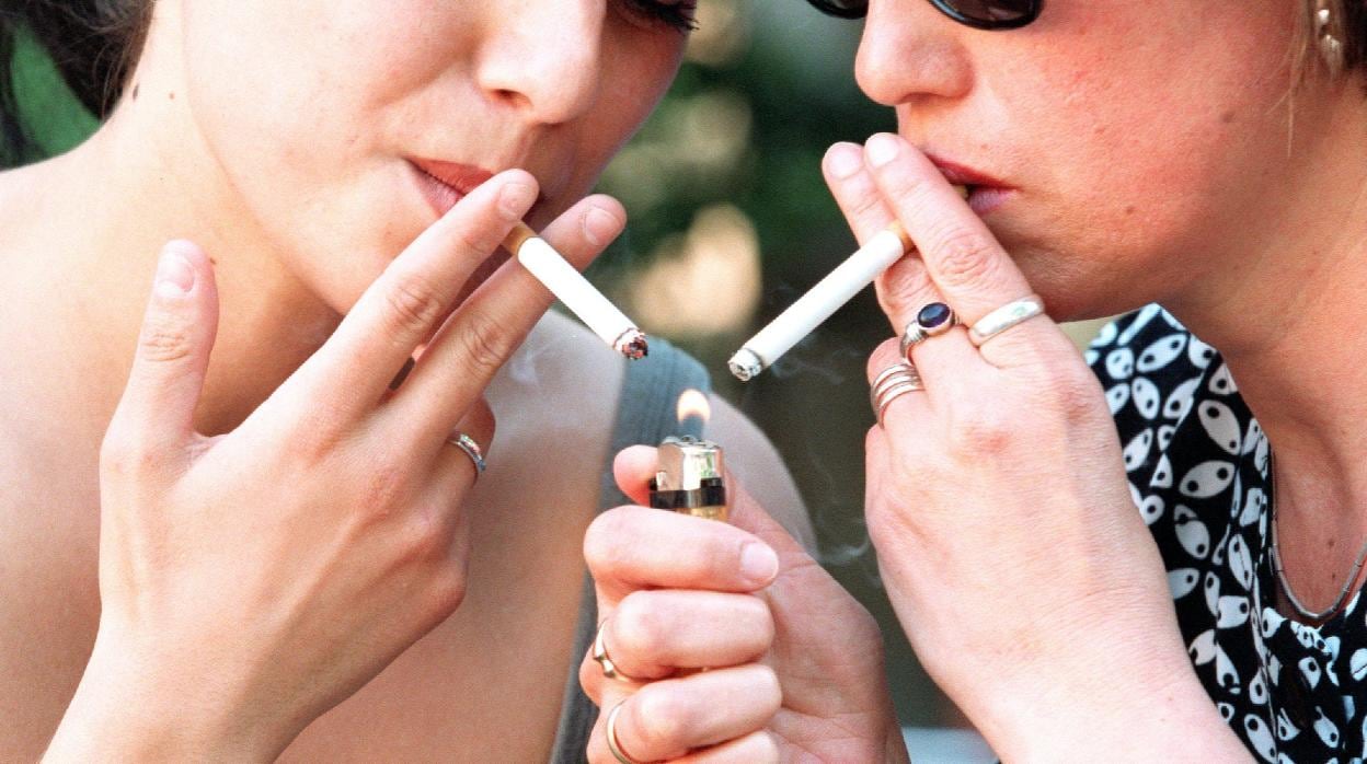 Dos jóvenes fuman en la calle