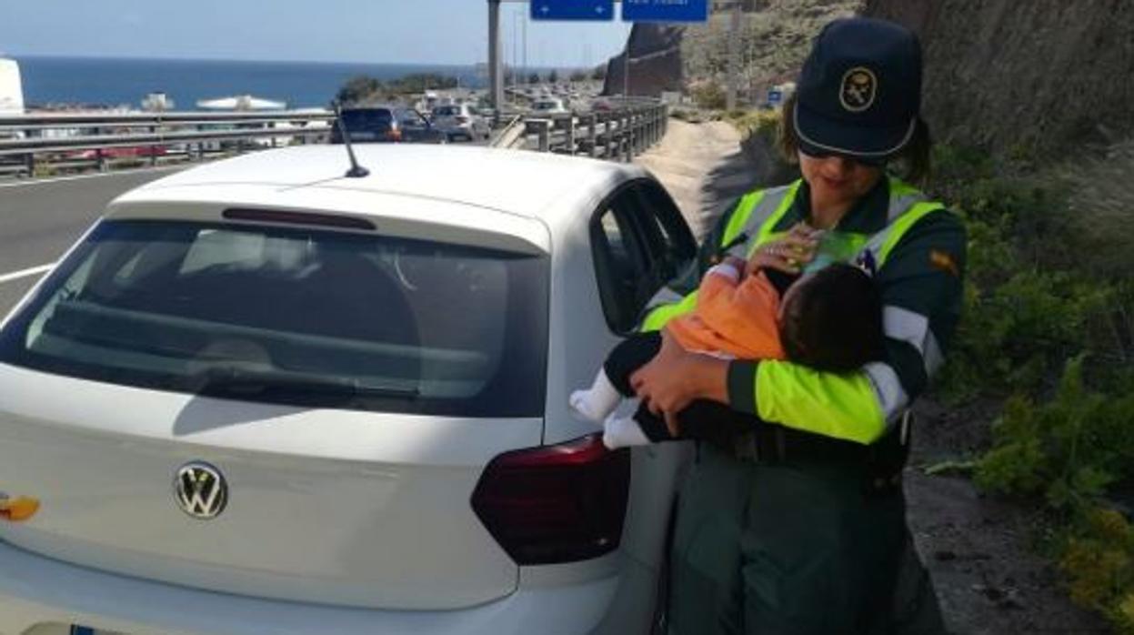Una guardia civil cuida de un bebé cuyo padre había sufrido un amago de infarto al volante