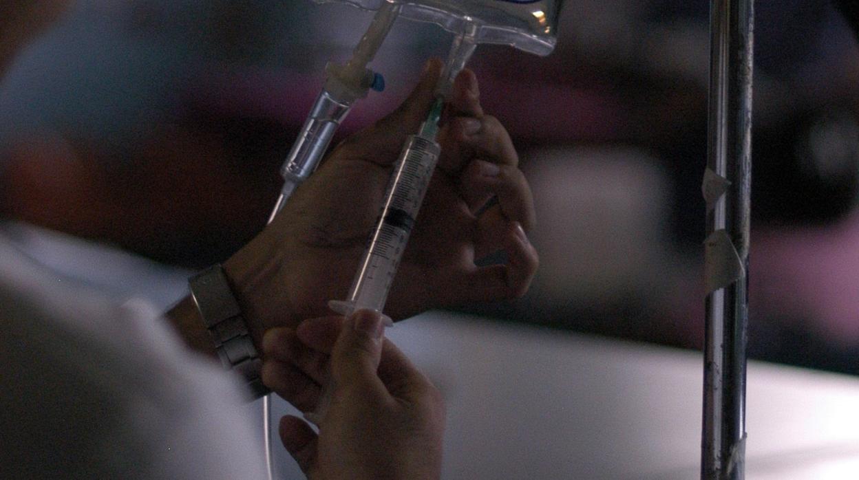 Un médico internista coloca una solución intravenosa