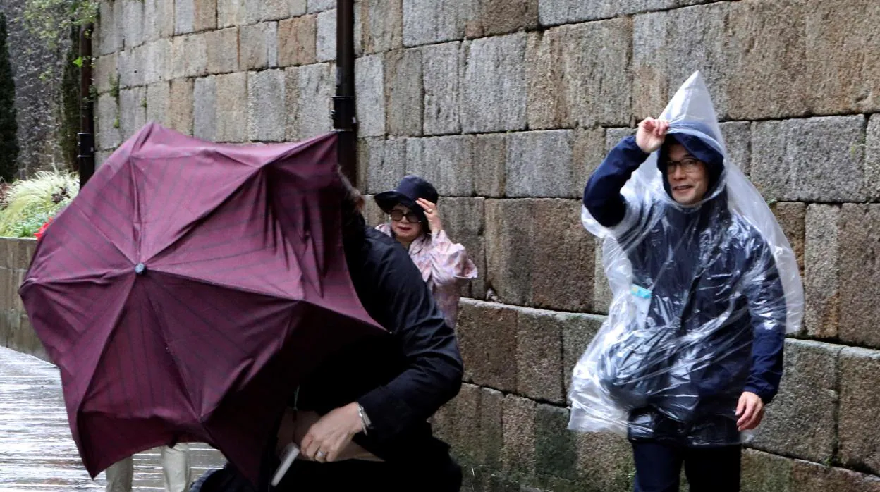 Turistas japoneses luchan por no perder sus paraguas en Santiago de Compostela