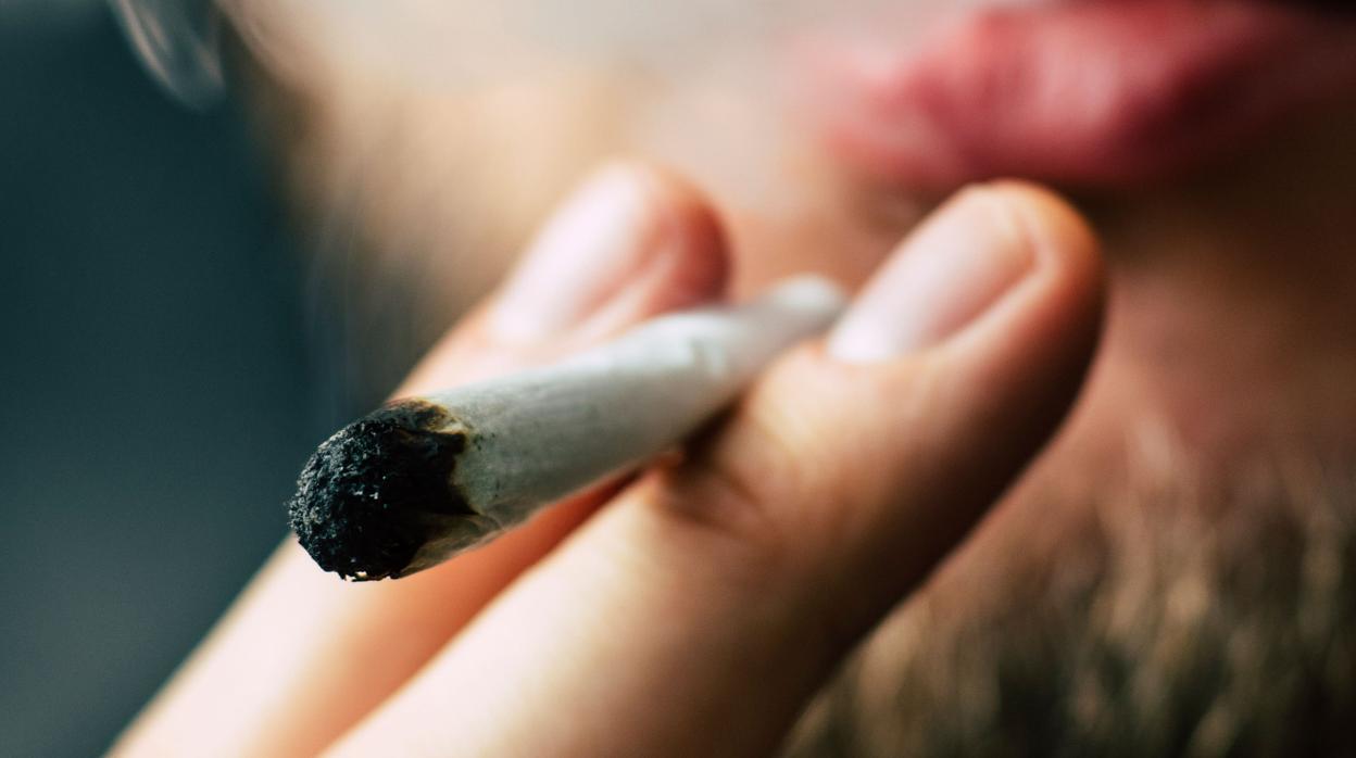 Un hombre da una calada a un cigarro de marihuana