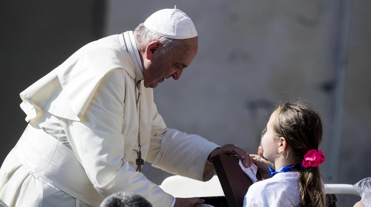 El papa Francisco saluda a una niña a su llegada a la audiencia general en la plaza de San Pedro en el Vaticano