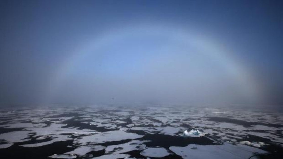 Un arco iris aparece en el horizonte en el Ártico