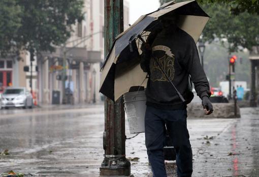 Un hombre se protege de la lluvia provocada por el huracán Barry en Nueva Orleans