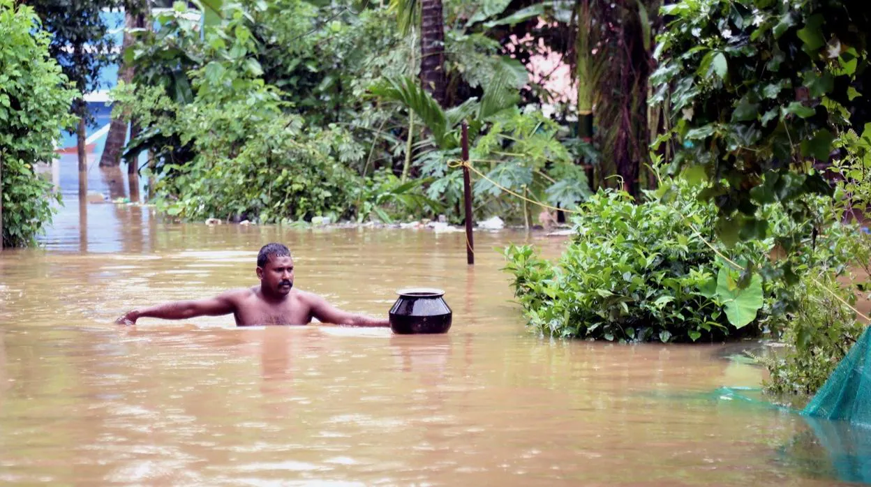 Un hombre camina en por las calles inundadas de la ciudad de Kochi, en Kerala (India)