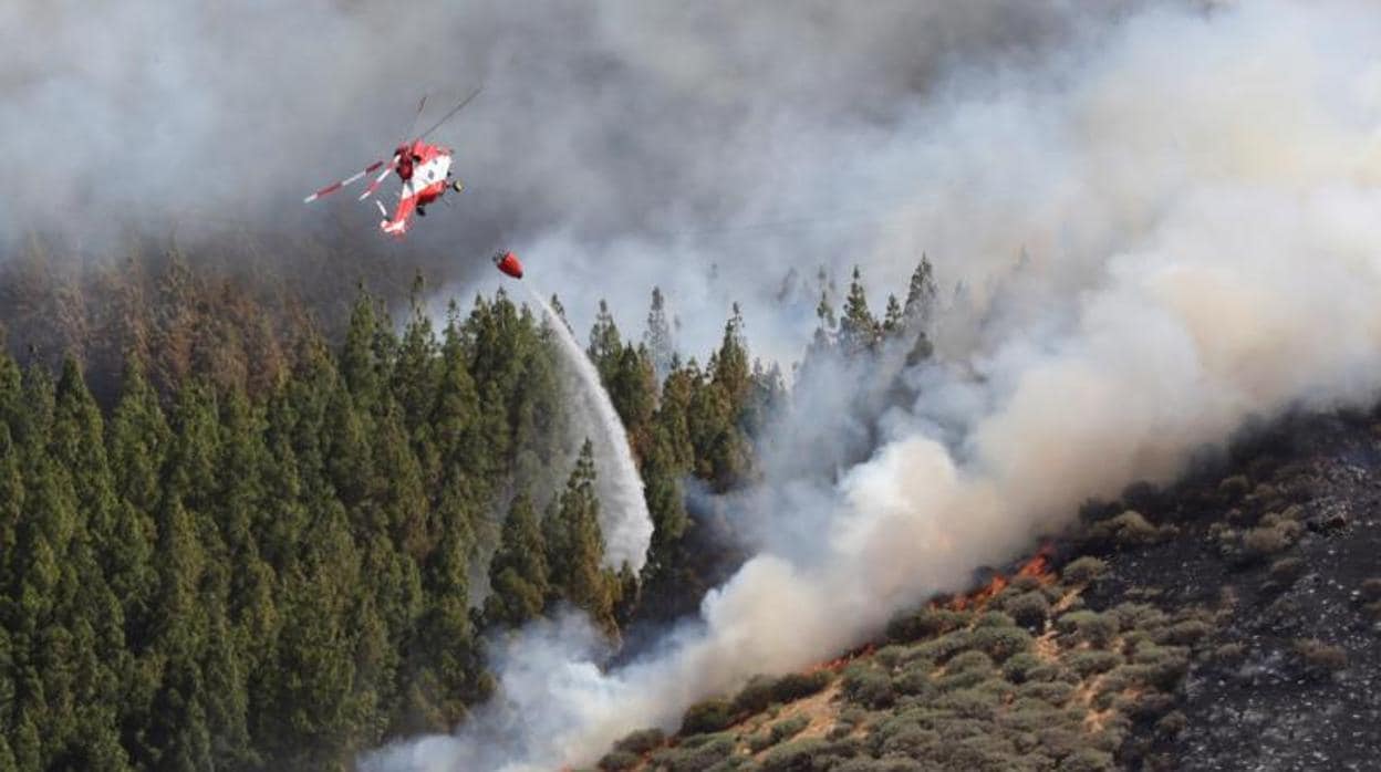 Un helicóptero en el incendio declarado este sábado en la zona de Artenara en el oeste de la isla de Gran Canaria