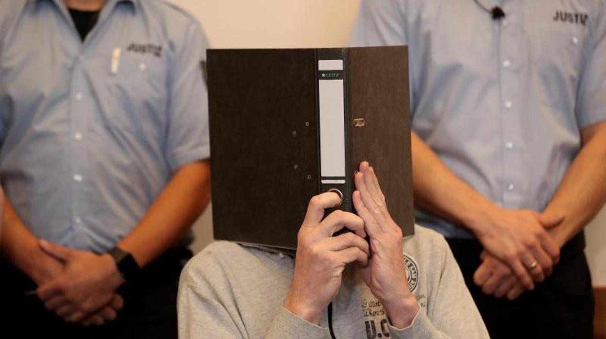 El acusado de haber abusado de al menos 23 menores Andreas V. cubre su rostro a su llegada al juzgado de primera instancia de Detmold (Alemania)