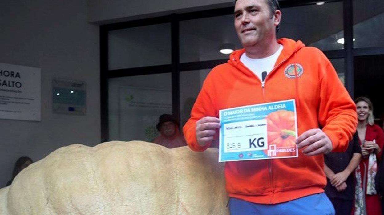 Fotografía facilitada por el Ayuntamiento de Paredes (Oporto, Portugal), del agricultor Rubén Mendí junto al ejemplar gigante de calabaza de 825 kilos con que acaba de ganar un concurso