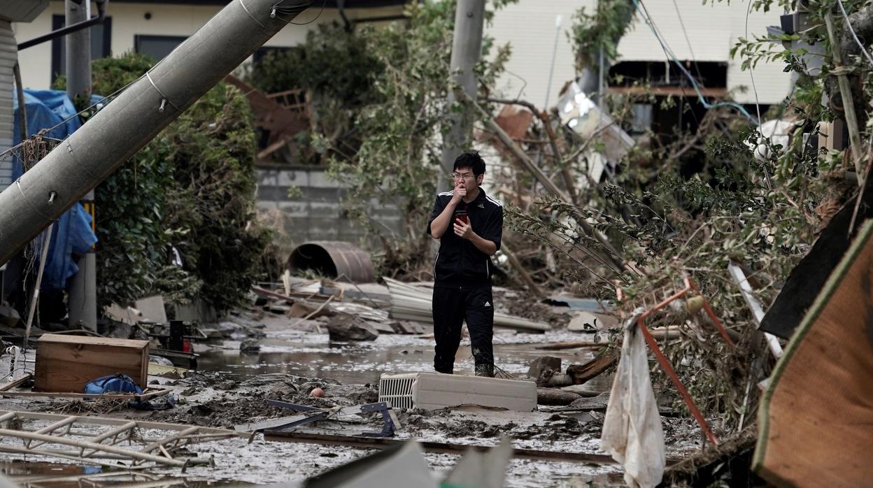 Un joven toma una fotografía de los destrozos que ha dejado el tifón Hagibis a su paso por Nagano (Japón)