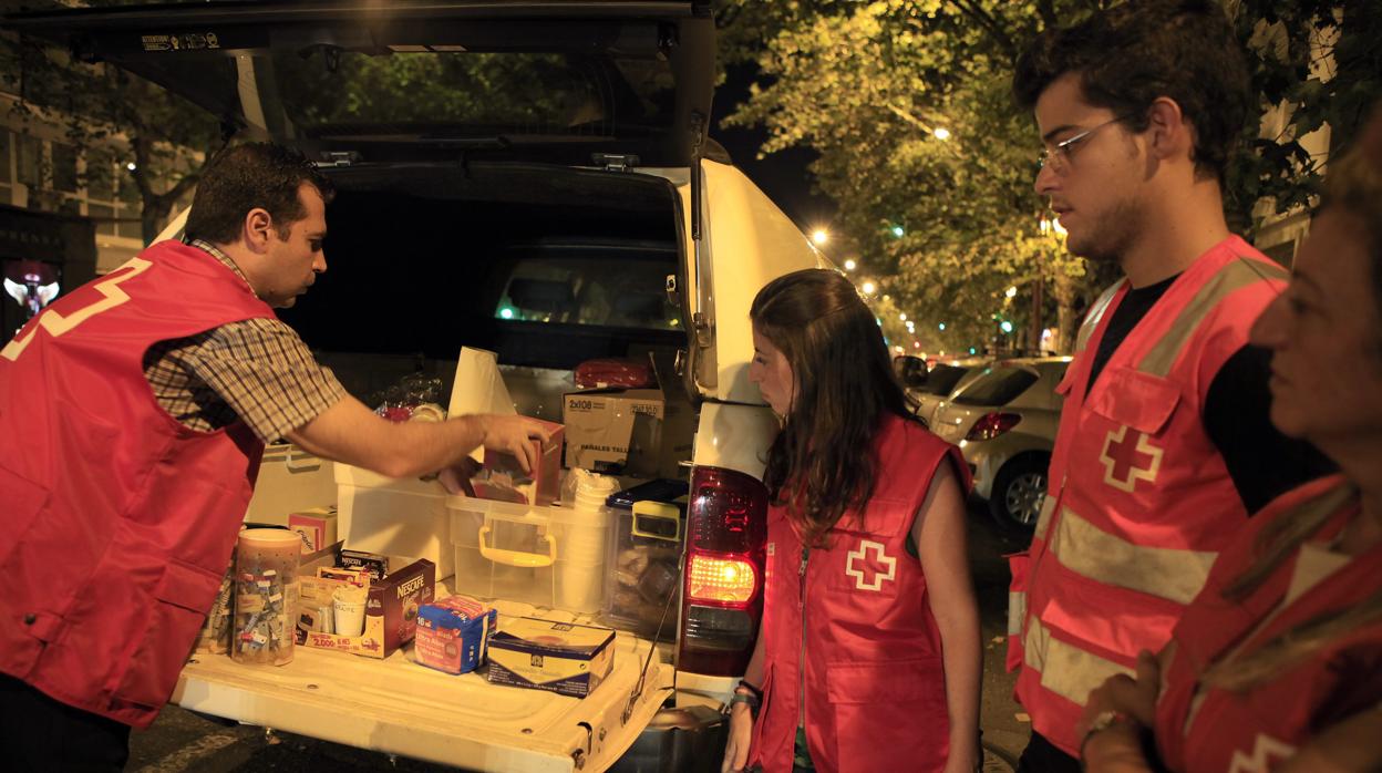 Voluntarios de Cruz Roja reparten comida en la calle