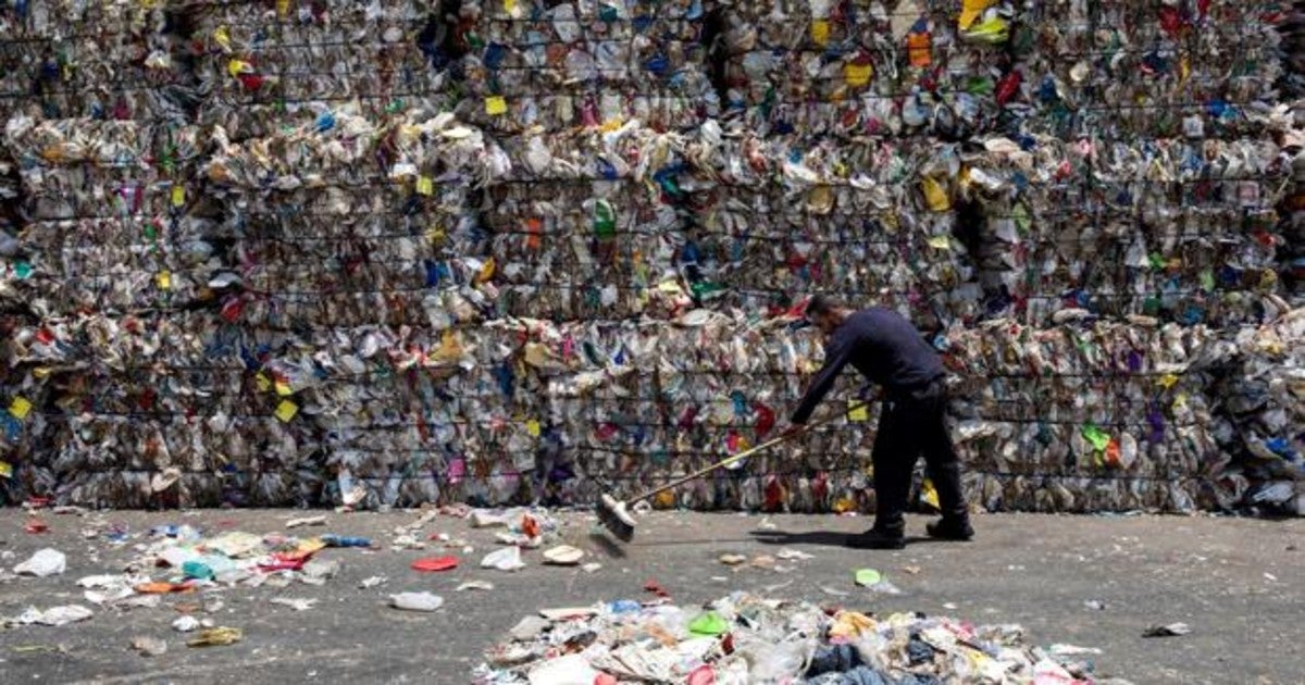 Un barrendero recopila basusa en un complejo de reciclaje