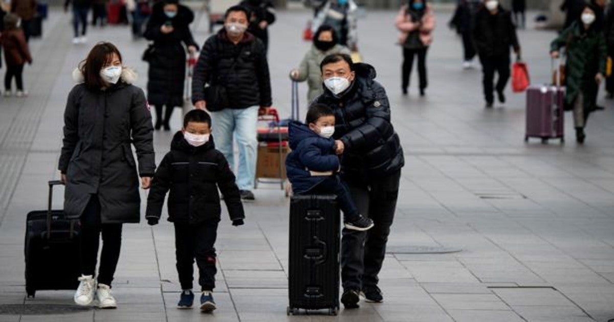 Pasajeros llevando máscaras en la estación de tren de Beijing