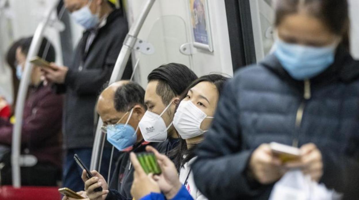 Gente viajando en metro con una mascarilla en Guangzhou