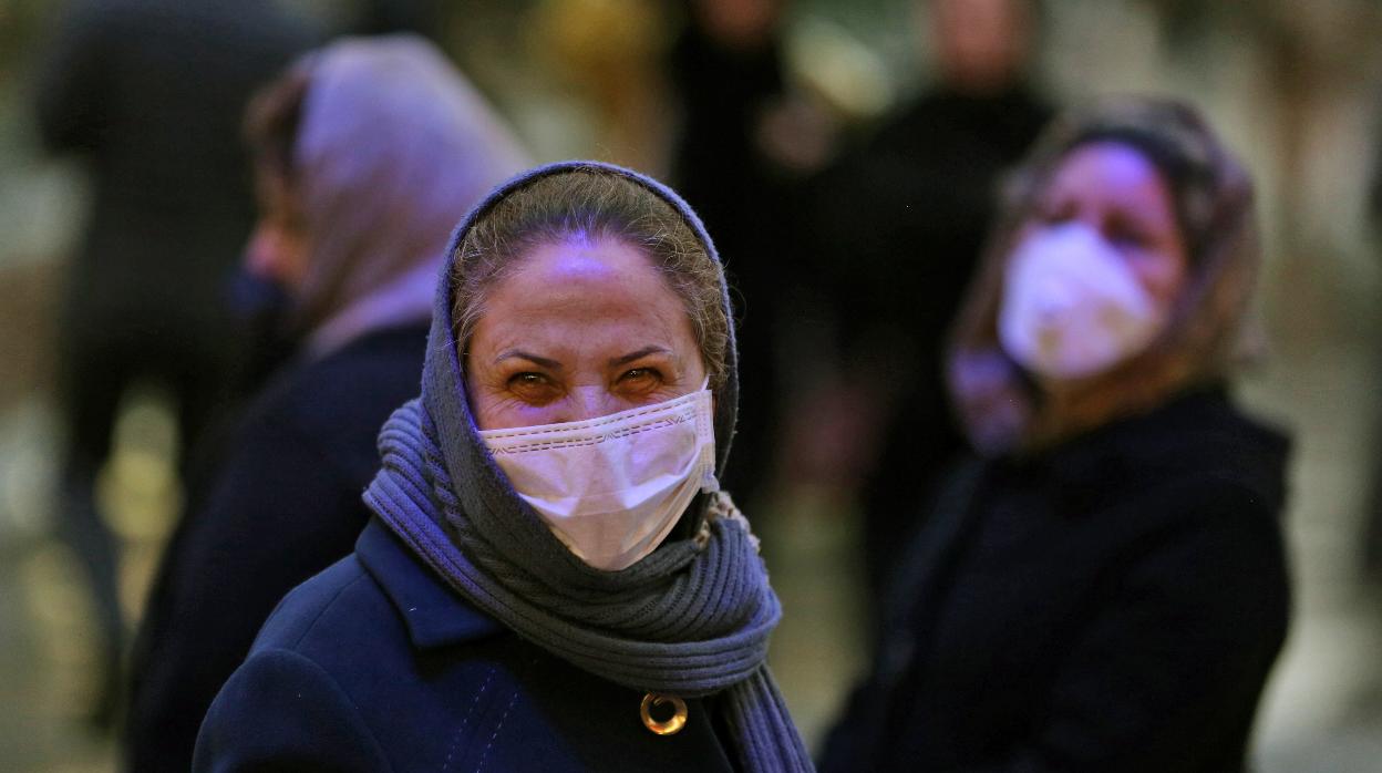 Una mujer iraní en la calle con mascarilla