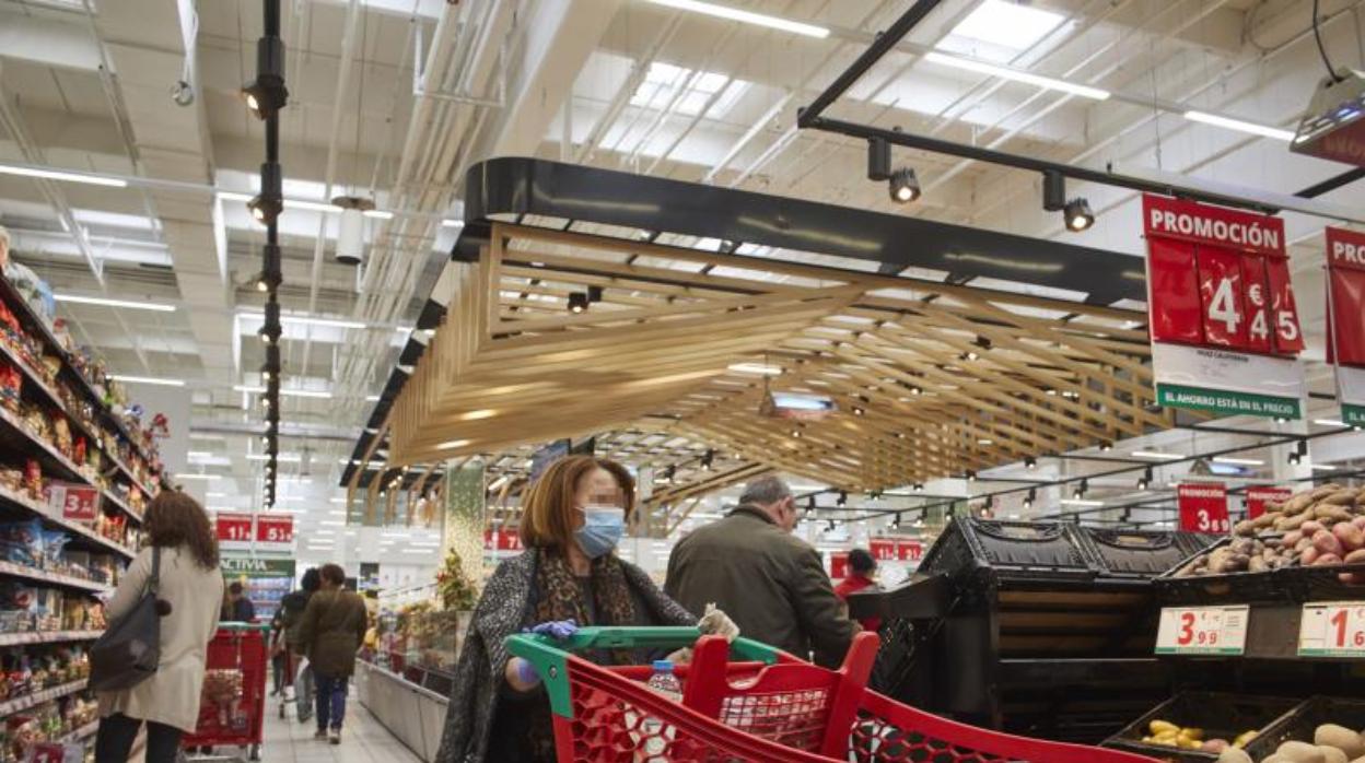 Una mujer comprando con mascarilla en un hipermercado de Madrid