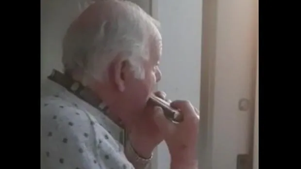 Un anciano con alzheimer toca la armónica en el balcón al creer que los aplausos a los sanitarios son para él