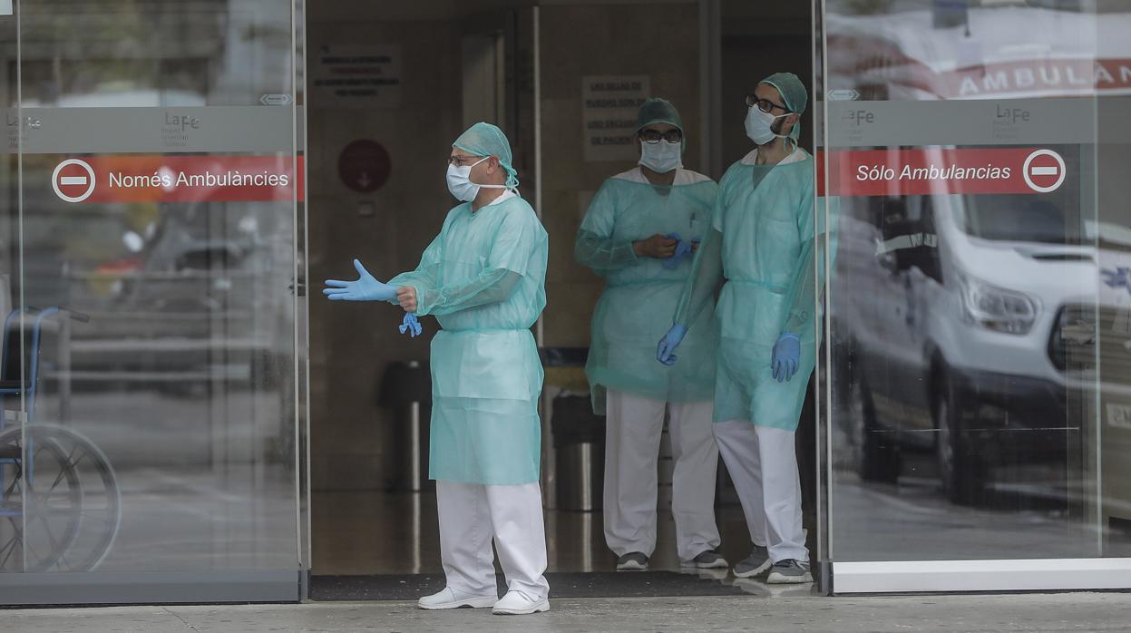 Fotografía de archivo de personal sanitario protegido con mascarillas a las puertas de un hospital