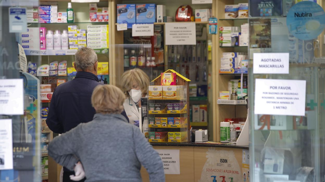 Una farmacéutica se protege del coronavirus con una mascarilla