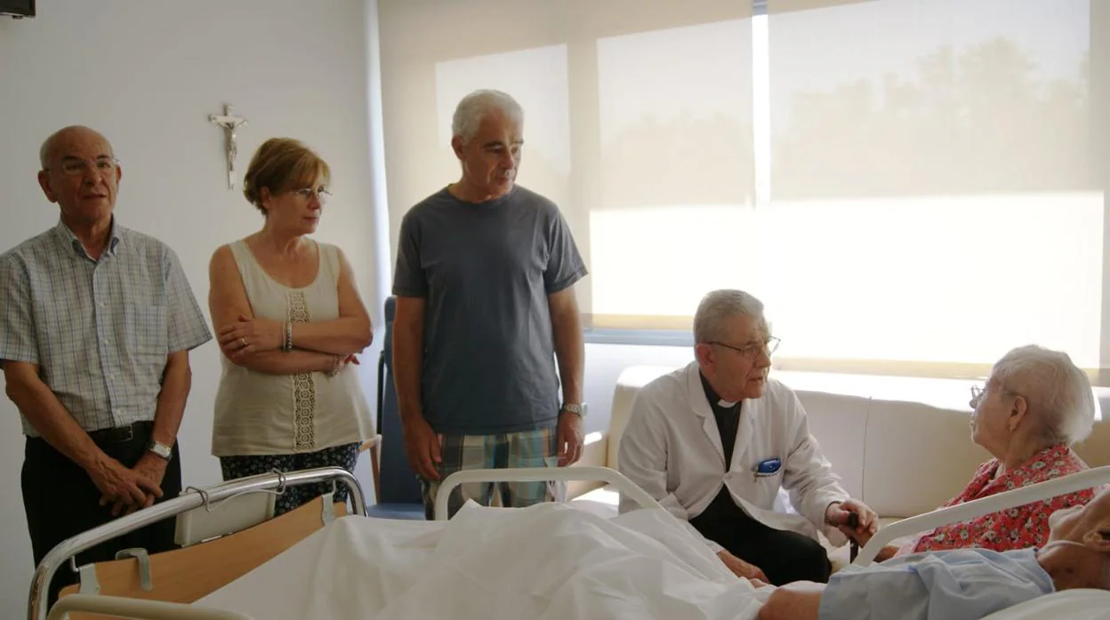 José Ruiz, de 80 años, consuela a los familiares de un paciente enfermo en el Hospital de Cuidados Laguna de Madrid